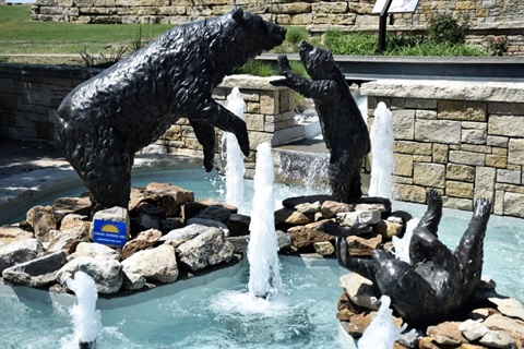 Mama bear and two cubs in fountain